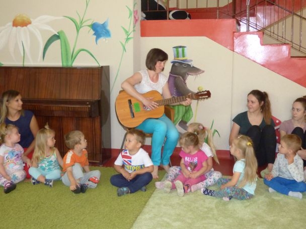 Pani gra na gitarze i śpiewa dzieciom