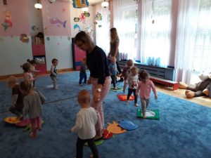dzieci z Paniami chodzą dookoła po ścieżce sensorycznej